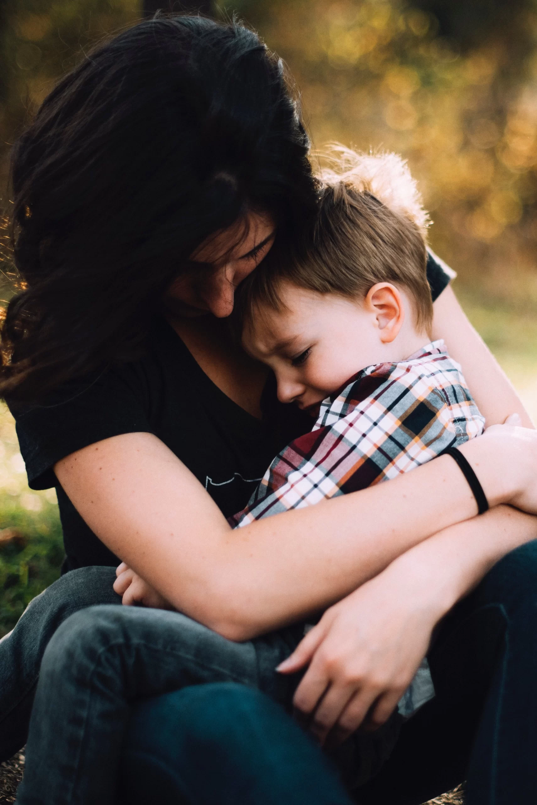 young boy with head on woman's chest